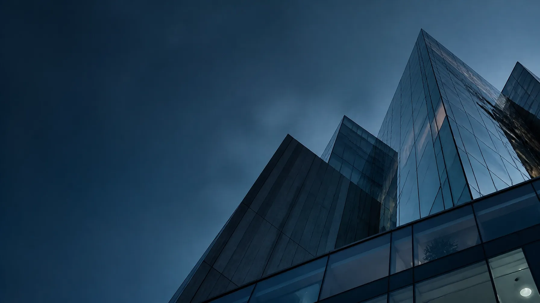 Looking up between modern buildings toward a clear horizon